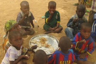 Schoolkinderen in Hondobon, Niger die een maaltijd krijgen