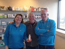 Marieke, Jan Kramer en Martin met de eerste gevulde fles showergel voor de oranjeverenigingen