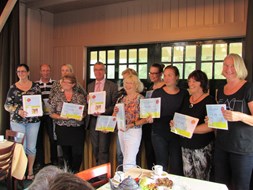 Alle Interne Cultuur Coordinatoren op de foto met de map en cheque